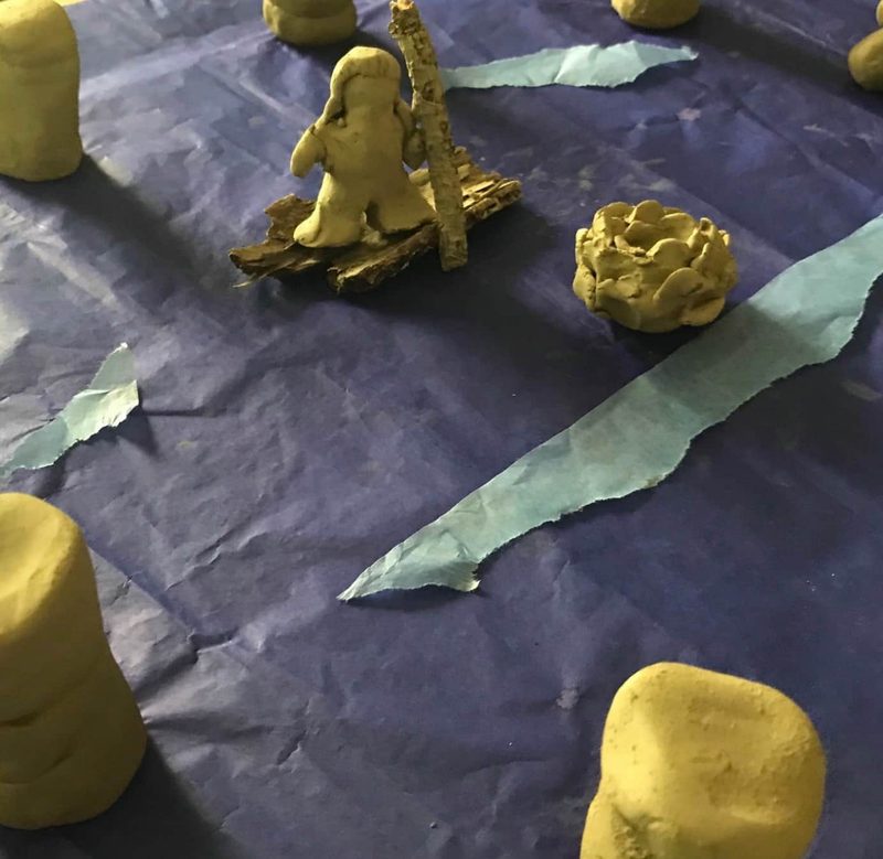 Kleine Tonfiguren auf violettem Papier